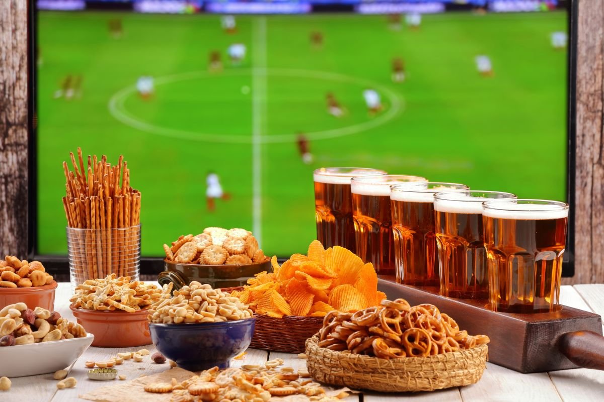 Amigos bebendo cerveja e assistindo jogo de futebol