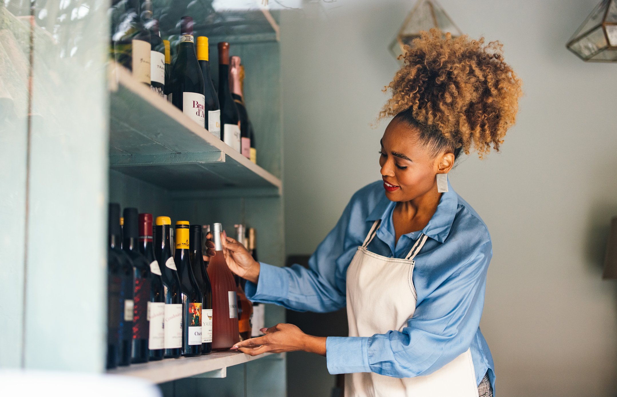 mulher organizando garrafas de vinho