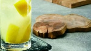 Copo com caipirinha de cachaça, limão siciliano, laranja, gengibre e água de coco
