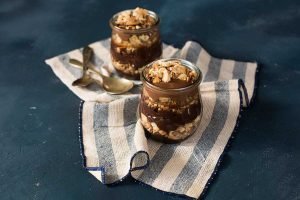 Sobremesa de surpresa de chocolate belga com creme de avelã e crocantes em copos com granulado, acompanhada de pote de chocolate