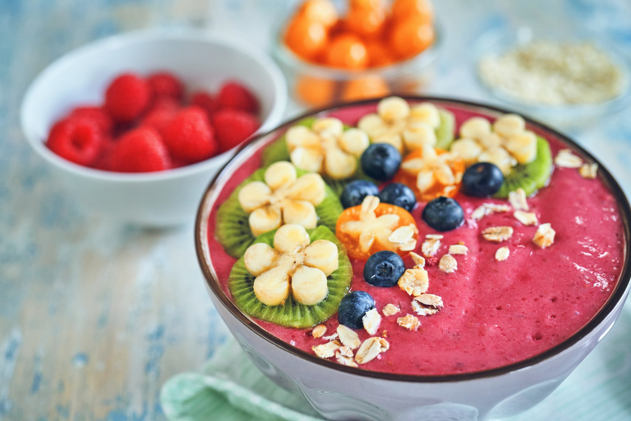 Smoothie bowl de pitaya vermelha decorado com granola, kiwi, blueberry e frutas frescas, mostrando formas de consumo da fruta versátil