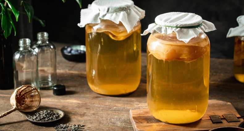 Potes de vidro com kombucha em diferentes estágios de fermentação.