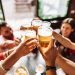 Grupo de pessoas brindando com cerveja em um bar