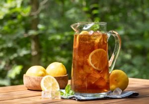 Chá em uma jarra de vidro, com muitas pedras de gelo e limão, ideais e refrescantes para piquenique