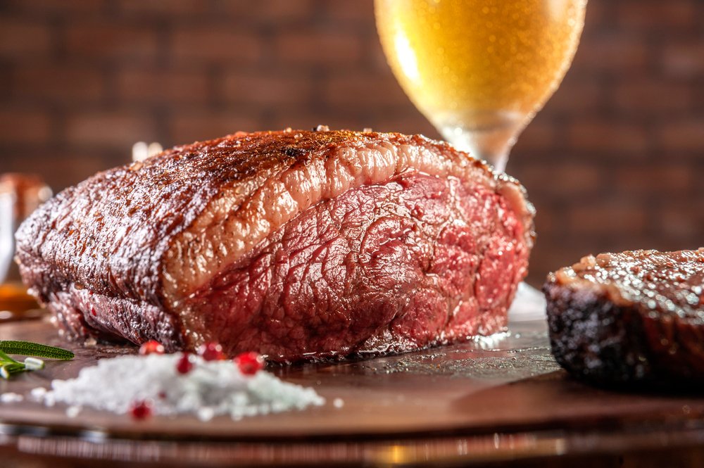 Picanha perfeitamente grelhada com fundo desfocado.