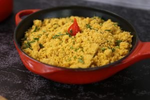 Farofa de banana com pimentinha em uma panela vermelha.