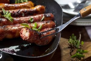 Linguiça cuiabana grelhada em uma frigideira.