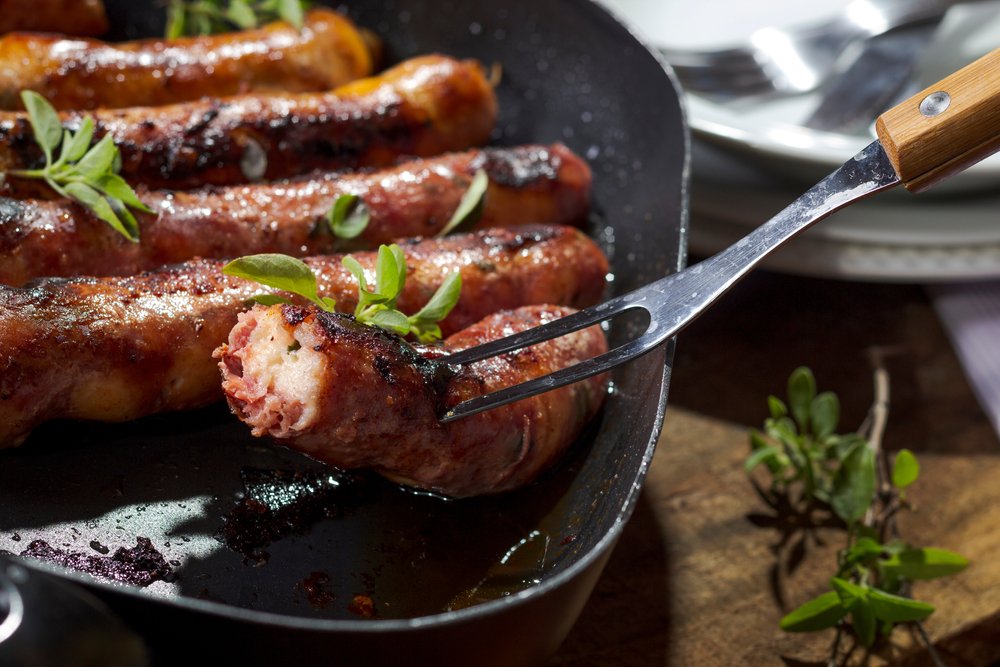Linguiça cuiabana grelhada em uma frigideira.