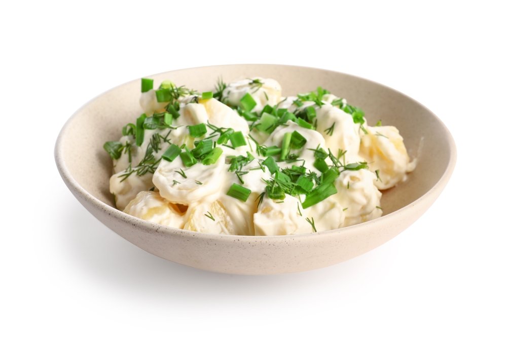 Maionese de batata decorada com ervas frescas em tigela.