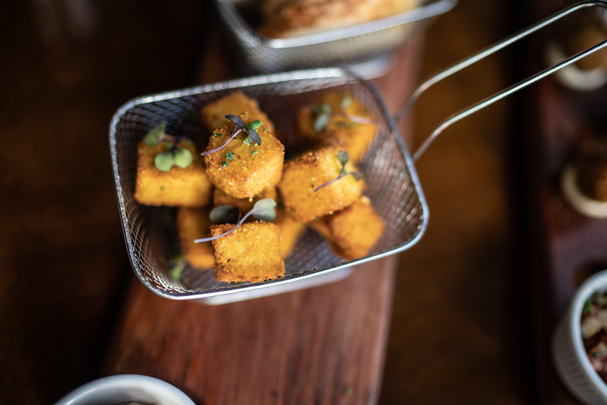 Cubos de polenta frita em uma cesta de fritura.