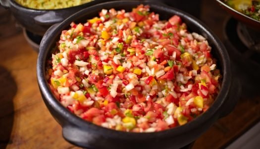 Salada de tomate em tigela de barro, ideal para acompanhamento de churrasco.