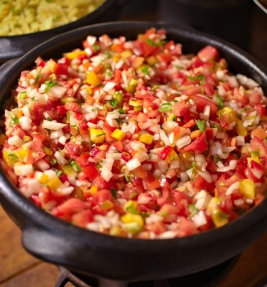 Salada de tomate em tigela de barro, ideal para acompanhamento de churrasco.