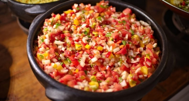 Salada de tomate em tigela de barro, ideal para acompanhamento de churrasco.