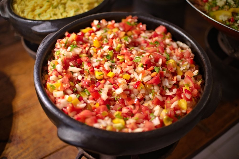 Salada de tomate em tigela de barro, ideal para acompanhamento de churrasco.