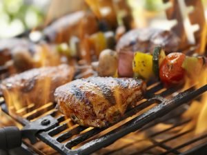 Sobrecoxa de frango grelhada com legumes na churrasqueira.
