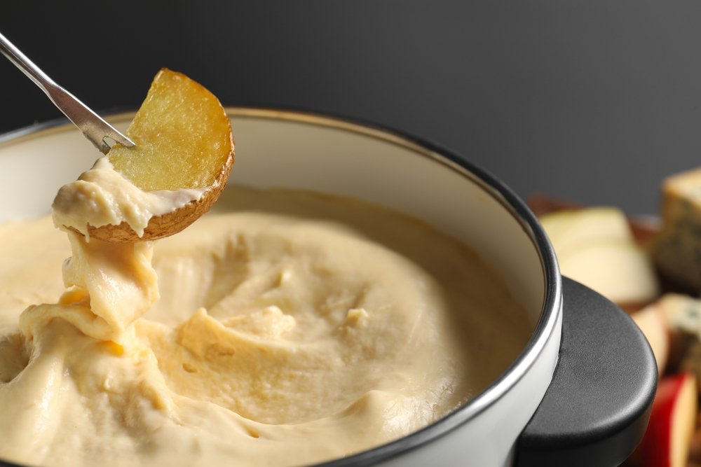 Fondue de creme de batata com um pedaço de batata.