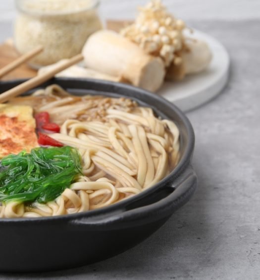 lamen vegetariano com cogumelos enoki, tofu e algas em caldo claro