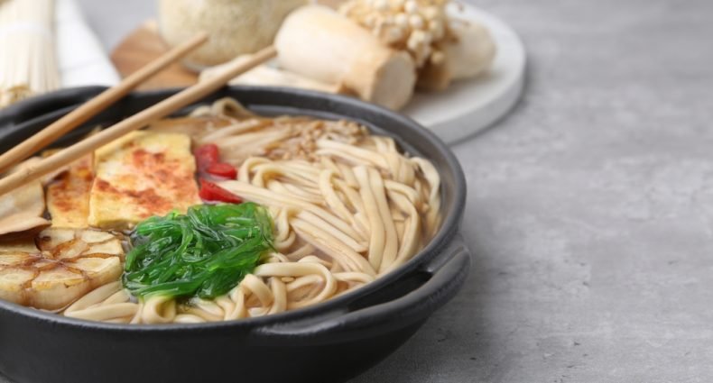 lamen vegetariano com cogumelos enoki, tofu e algas em caldo claro