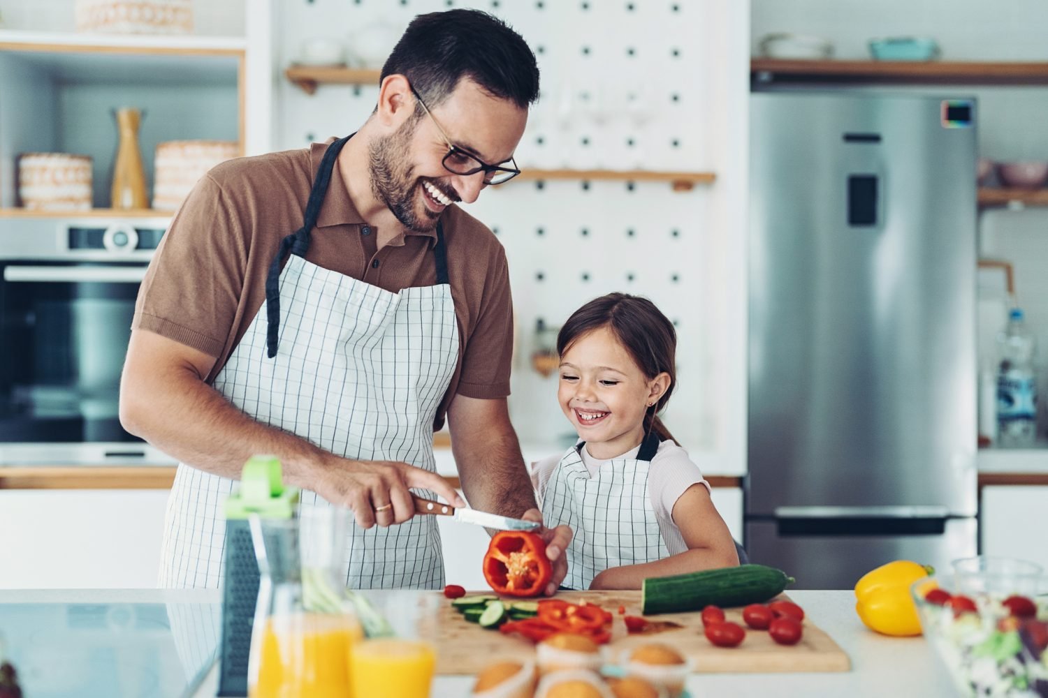 pai jovem e filha pequena cozinham juntos para o almoço de dia dos pais