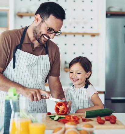 pai jovem e filha pequena cozinham juntos para o almoço de dia dos pais