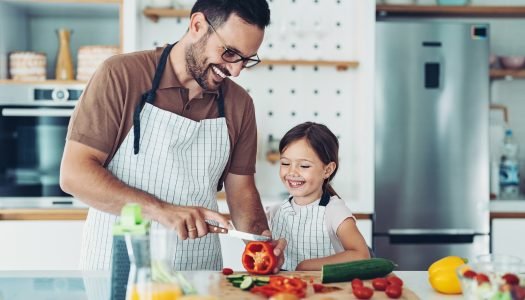 pai jovem e filha pequena cozinham juntos para o almoço de dia dos pais