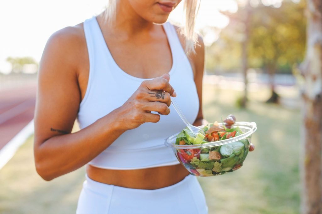 Mulher segurando uma salada fresca em um ambiente externo