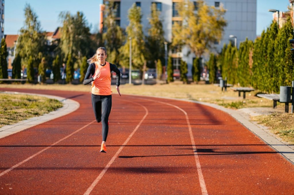 Mulher correndo em uma pista de atletismo