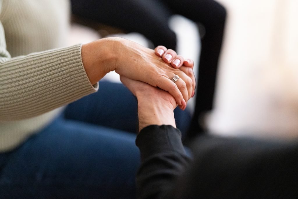 Duas pessoas dando as mãos em um gesto de apoio