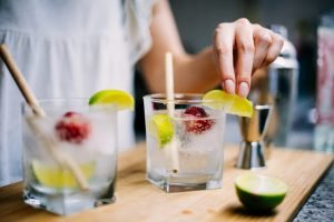 Copos de gin com limão e morango em uma tábua de madeira