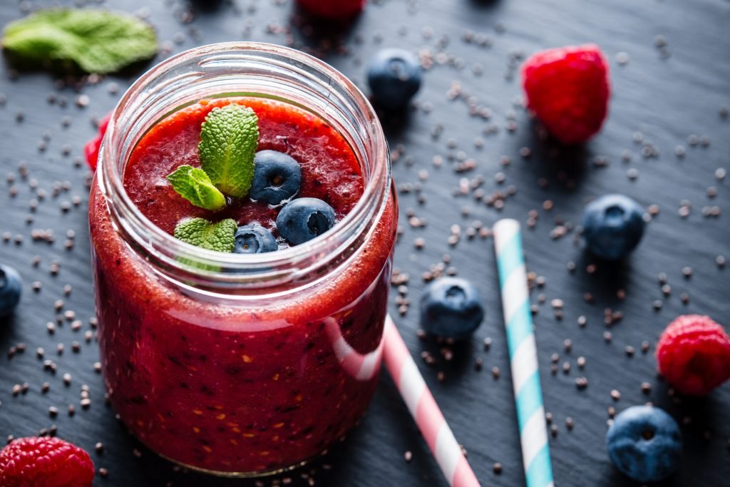 Bebida em copo transparente com água tônica e frutas vermelhas frescas