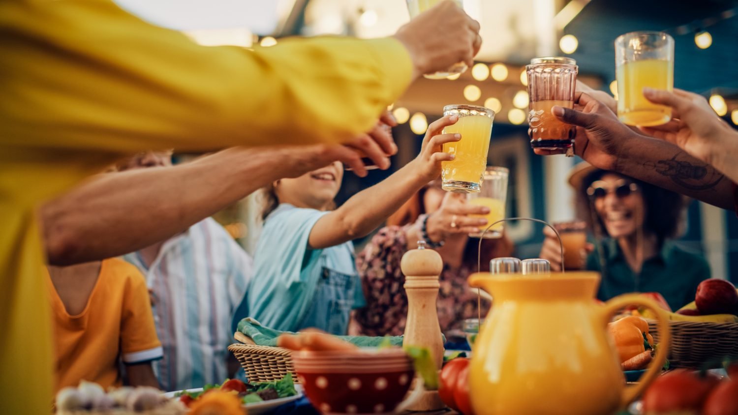 Pessoas ao redor de uma mesa brindando com drinques sem álcool