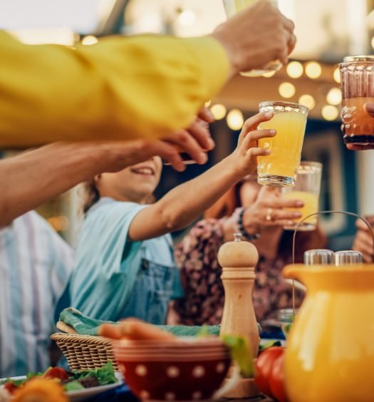 Pessoas ao redor de uma mesa brindando com drinques sem álcool