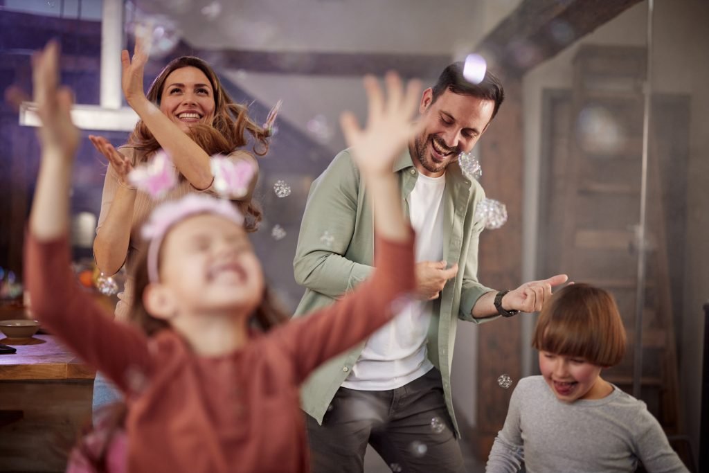 Família se divertindo com bolhas de sabão durante uma festa em casa