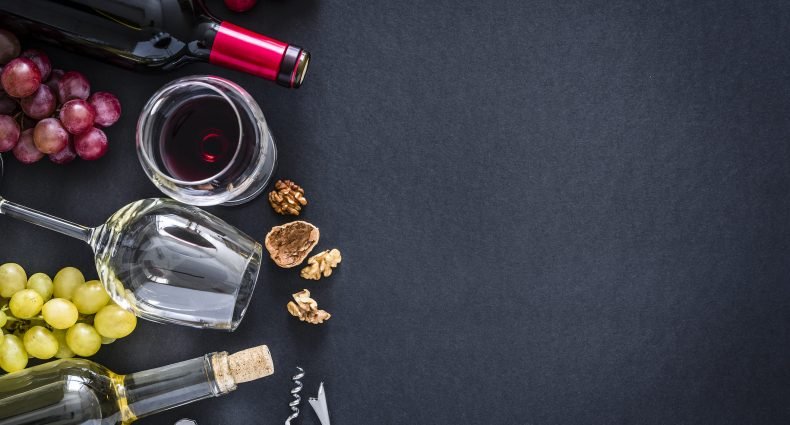 Vinho, taças e uvas em uma mesa