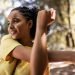 Mulher jovem sorrindo e alongando-se ao ar livre com fones de ouvido