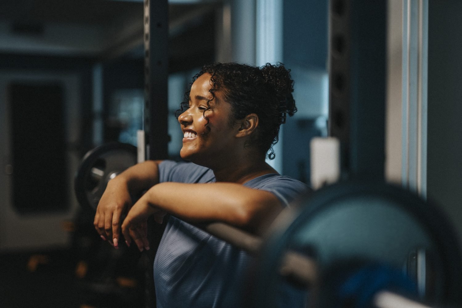 Mulher sorridente relaxando na academia após o treino