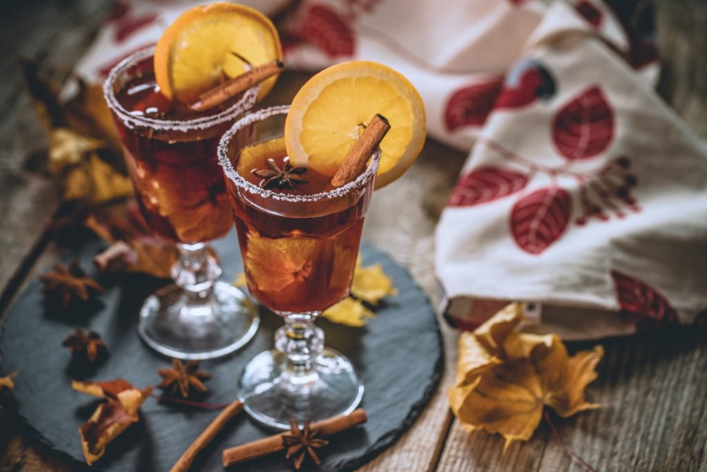 Quentão sem álcool decorado com fatias de laranja, canela e especiarias