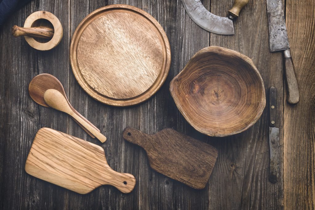 Conjunto de tábuas de madeira rústica para servir alimentos, dispostas sobre uma mesa de madeira