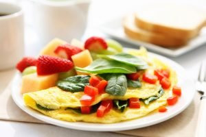 Omelete com espinafre, tomate e frutas