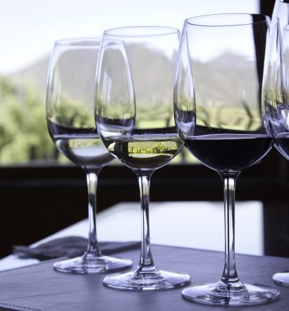 Taças de vinho sobre mesa com vista para montanhas