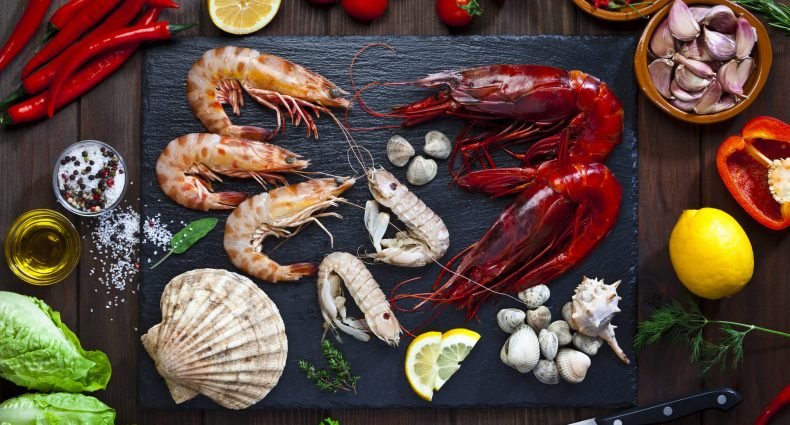 Diversos frutos do mar frescos dispostos sobre uma pedra