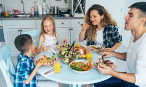 Família reunida à mesa com pratos variados