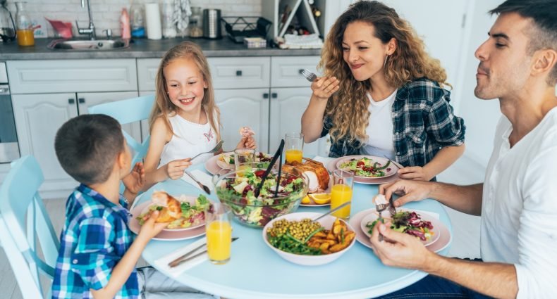 Família reunida à mesa com pratos variados