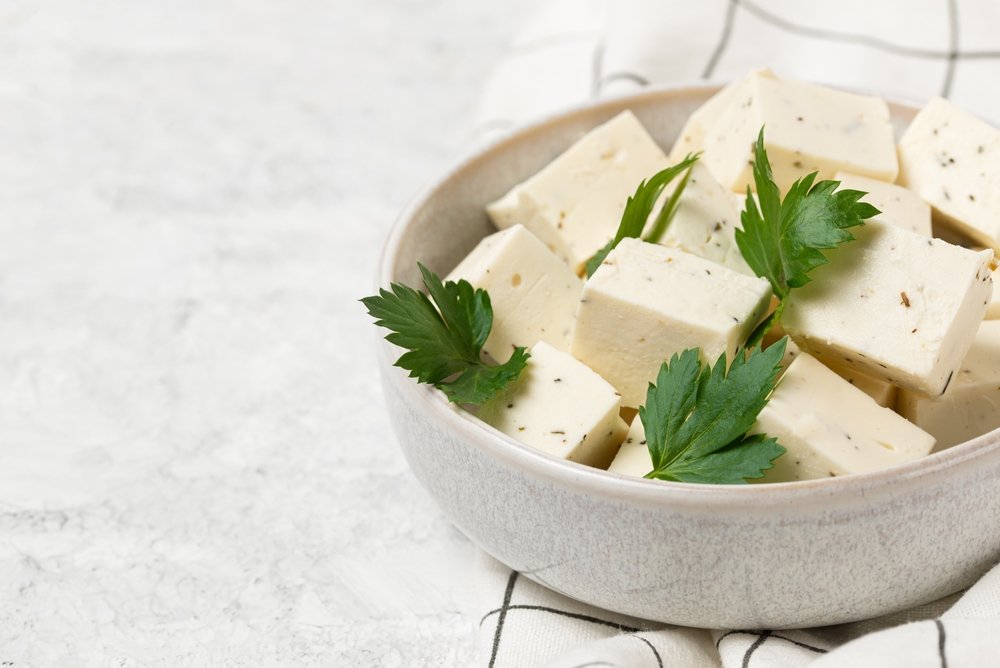 Ricota de tofu em um recipiente com ervas frescas