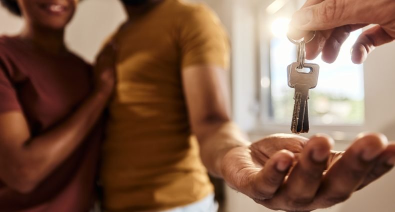 Mãos trocando chaves em uma nova casa