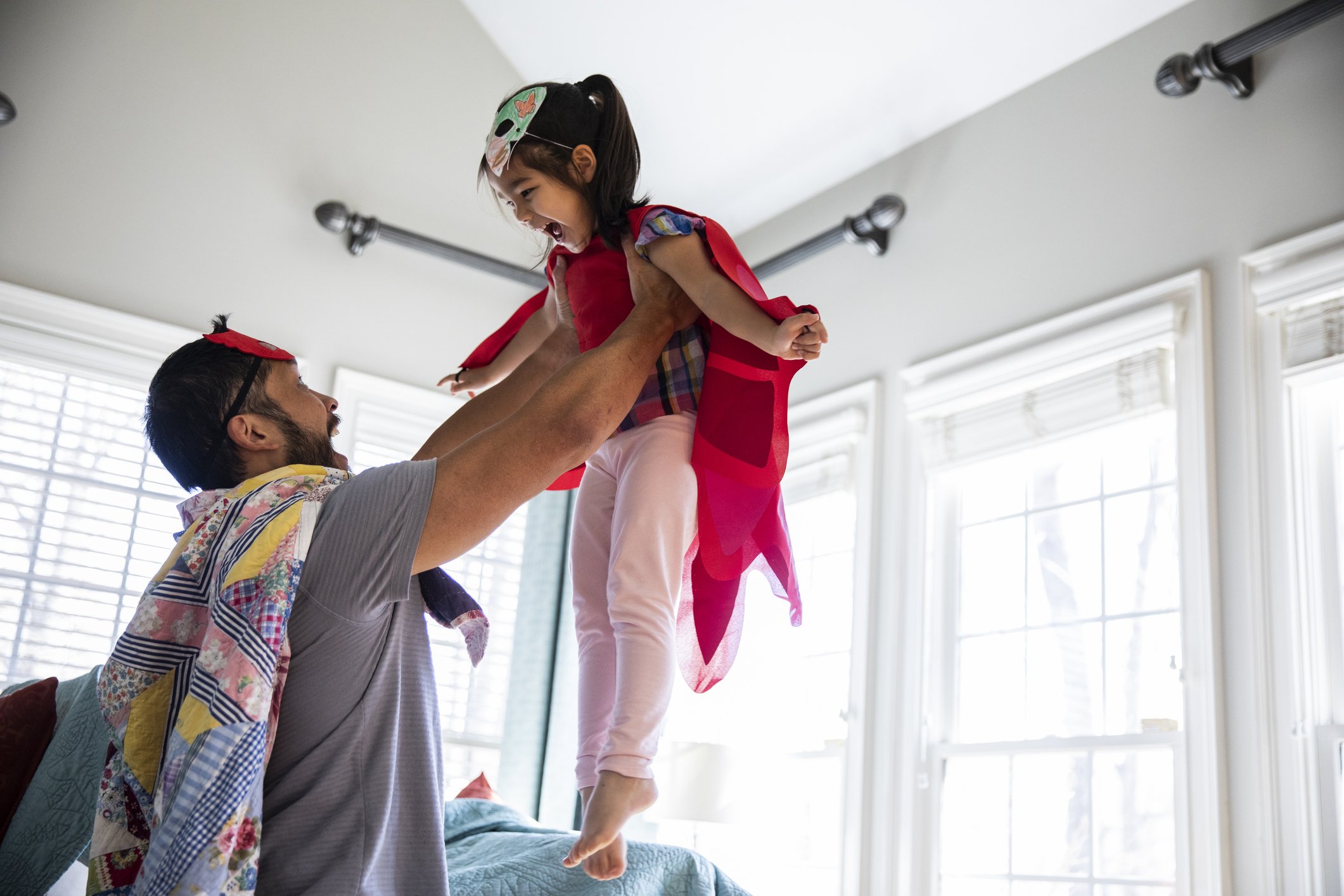 Pai brincando com filha em casa.
