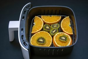 Fatias de frutas em uma airfryer.