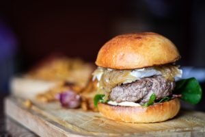 Hambúrguer com queijo de cabra cremoso e cebola caramelizada
