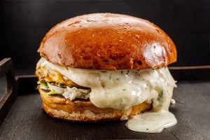 Delicioso hambúrguer com queijo mussarela derretido e molho cremoso