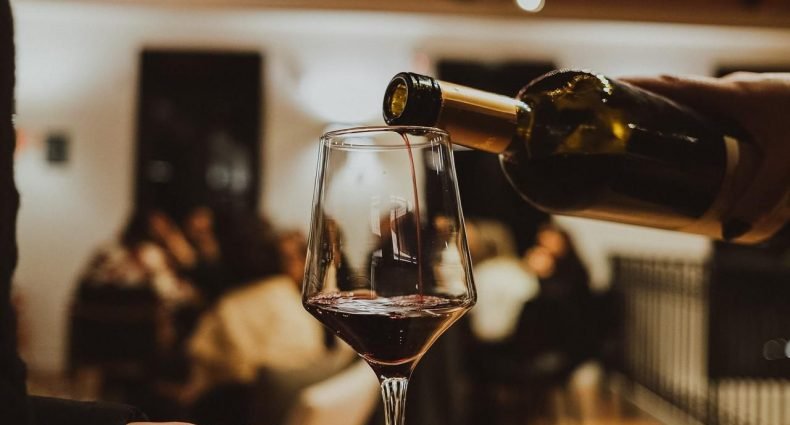 Taça sendo servida com vinho tinto durante a Experiência Cliente Mais Black em vinhedos gauchos